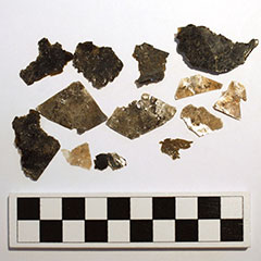 Photographie couleur de minéraux, très fins et parfois translucides. Certains morceaux sont noirs, tandis que d'autres sont presque blancs. Tous sont de formes et tailles différentes.