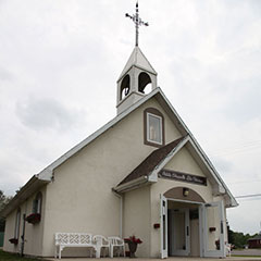 Colour photograph of a white chapel and its bell tower.