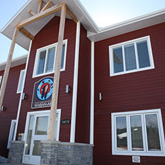 Colour photograph of a dark red wooden building.