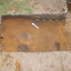 Photographie couleur de trois sections sombres sur un sol plus clair.