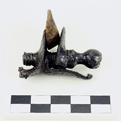 Photographie couleur d'un chien de fusil et d'une pierre à fusil en silex restaurés.